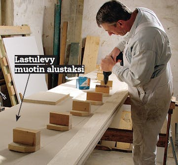 Lasikatto terassille: Rivi tukevia paloja ruuvataan levyyn kiinni Rivi tukevia paloja ruuvataan levyyn kiinni terassin lasikattoa varten